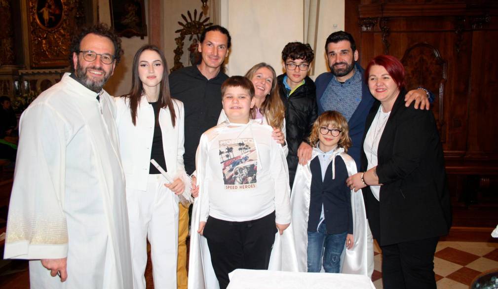 A sinistra Ethan e Matteo insieme alle loro famiglie e al parroco, don Stefano Vidotto, dopo aver ricevuto il Battesimo, durante la veglia pasquale